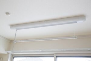 居室の窓上部に設置された照明器具と白い壁面