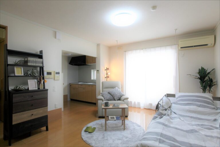 居室内観。ベッド、リビングエリア、キッチネット、トイレを備えた広々とした居住空間